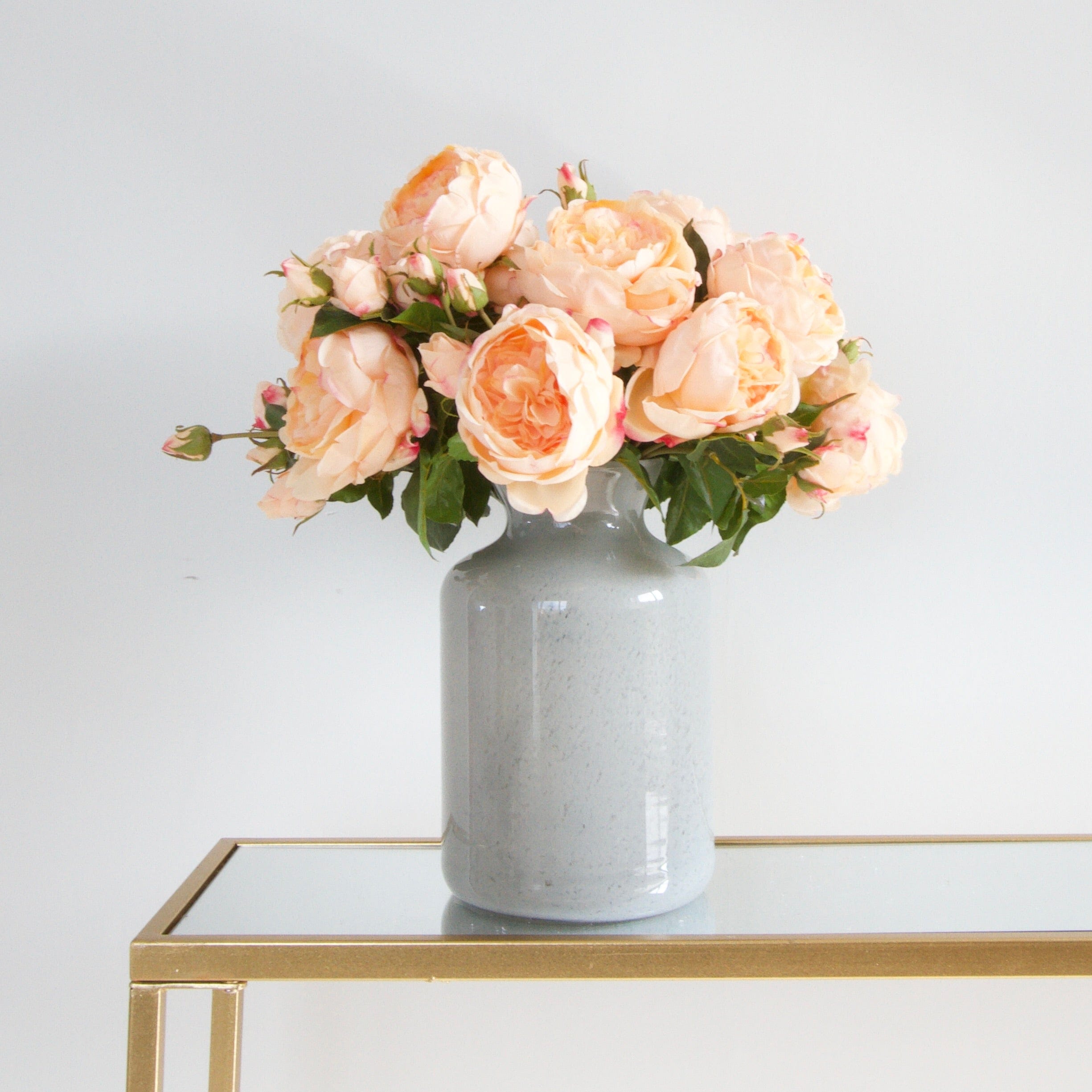 Luxury Lifelike Realistic Artificial Fabric Silk Blooms with Foliage Buy Online from The Faux Flower Company | 12 stems Peach English Rose ABY5013PC styled in Grey Glass Funnel Neck Vase ABV0144