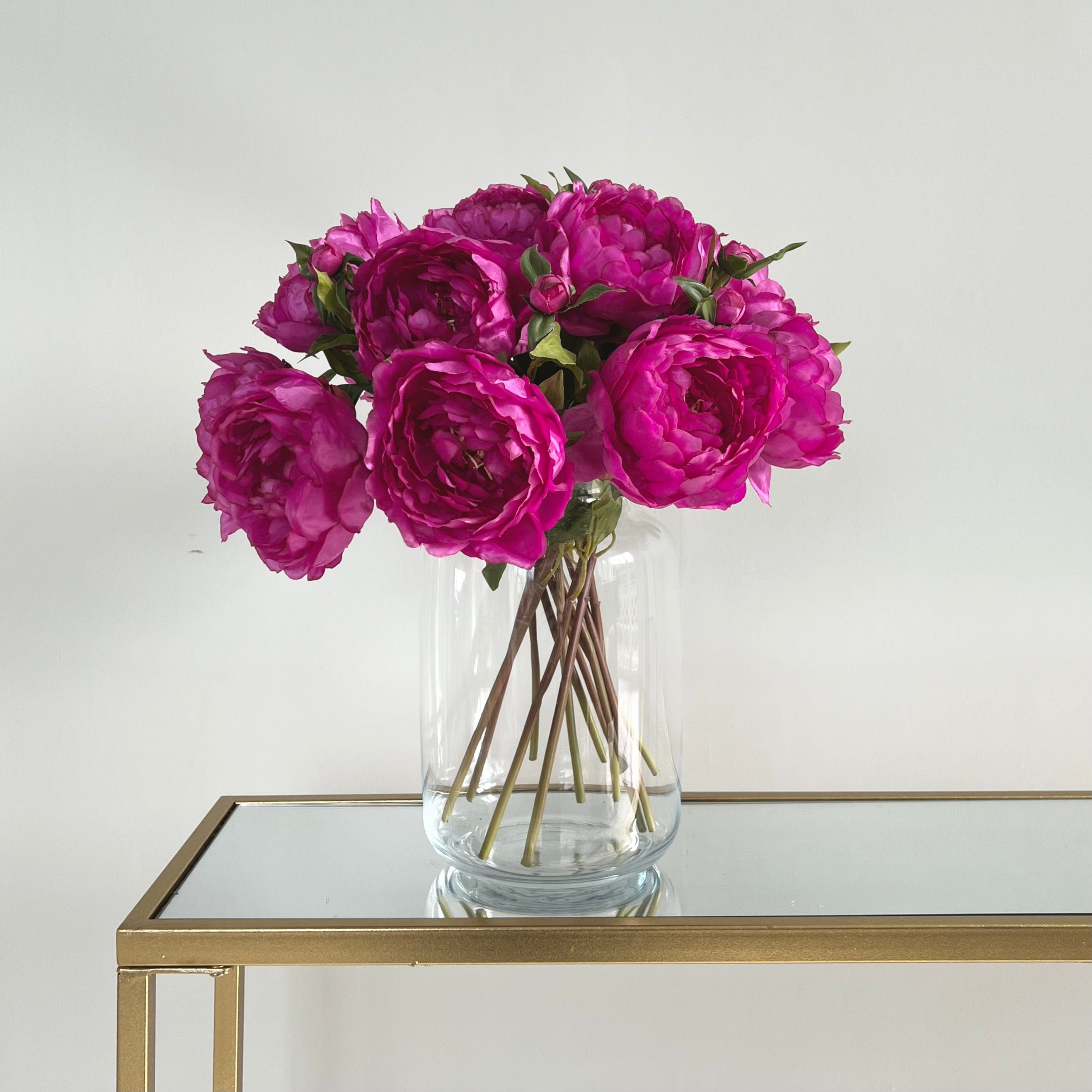 Luxury Lifelike Realistic Artificial Fabric Silk Blooms with Foliage Buy Online from The Faux Flower Company | 12 stems of Fuchsia Classic Peony ABY6043FU styled in Clear Glass Large Funnel Neck Vase ABV2253